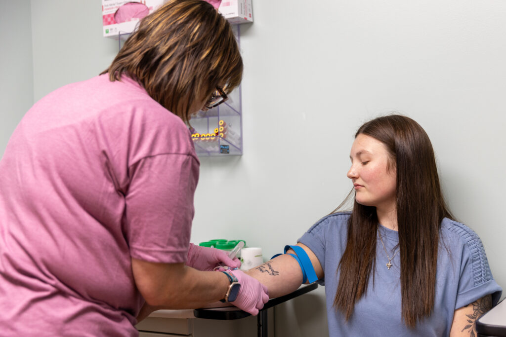 CHC lab technician prepping patient arm for lab work