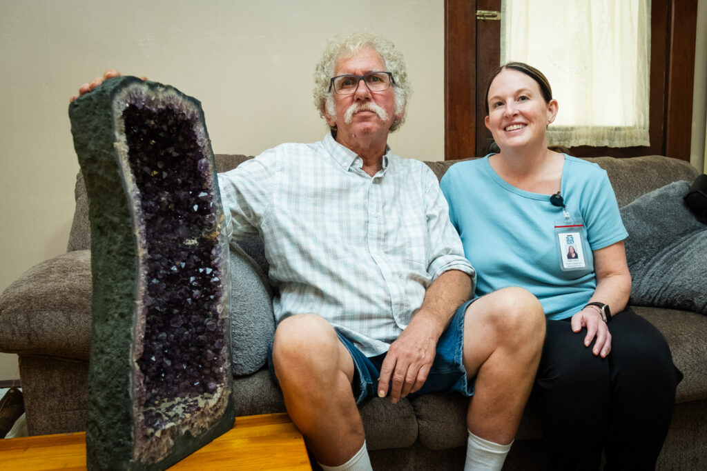 Man sitting on couch with amethyst geode
