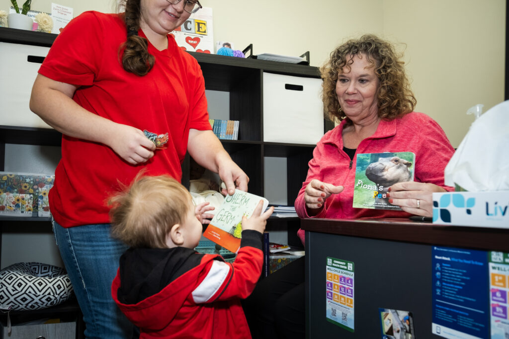 Mother and little boy look at books in office