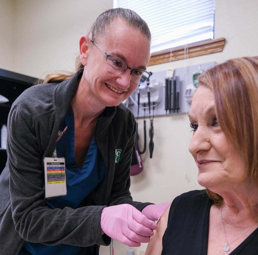 nurse administers flu shot for patient